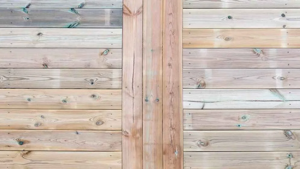 a close up bird's eyeshot of pressure treated wood, with vertical planks in the center connecting horizontal planks